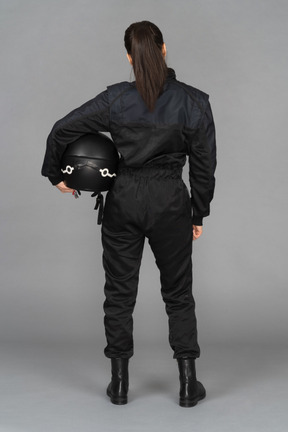 A female biker standing backwards to a camera