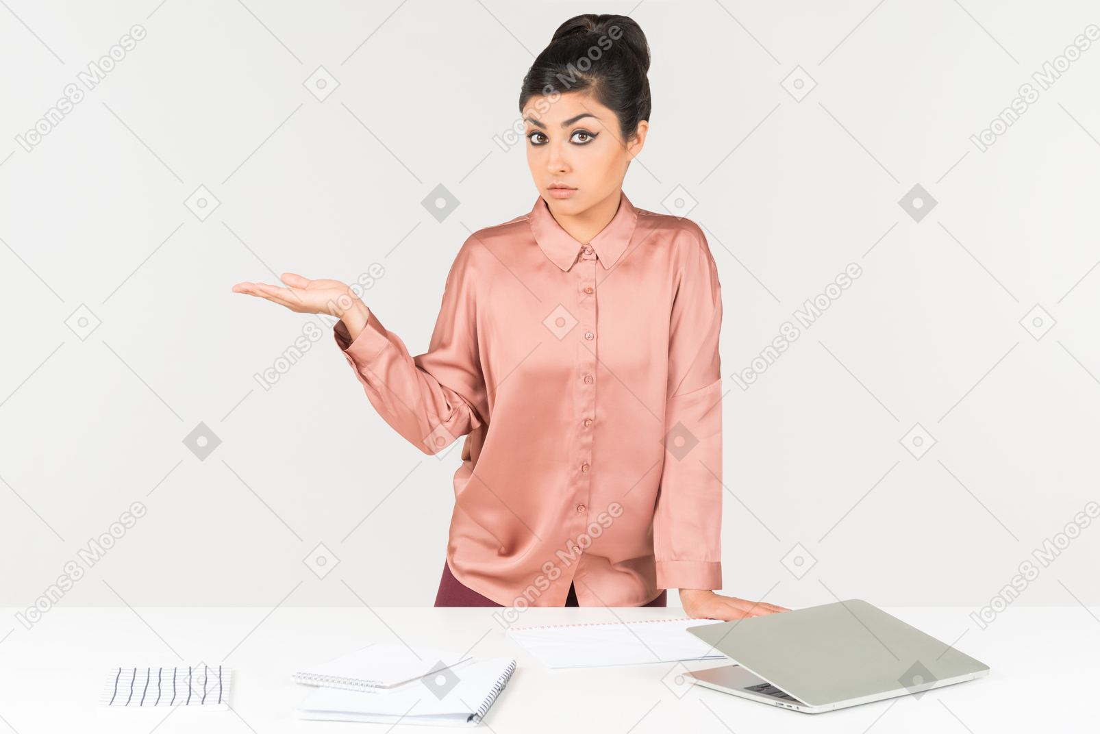 Oficinista indio de aspecto serio de pie en el escritorio de la oficina