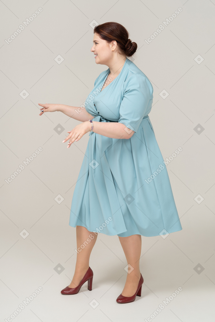 파란 드레스 포즈를 취하는 여자의 측면보기