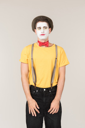 Male clown standing with his hands elongated