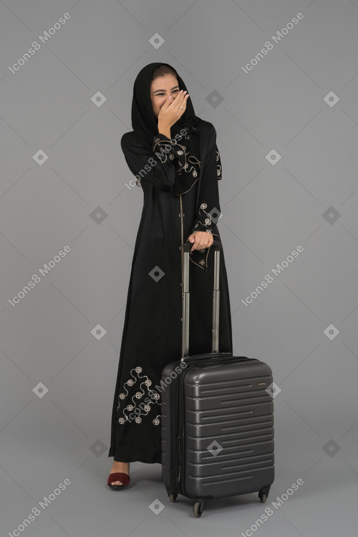 A laughing arab woman covering her mouth