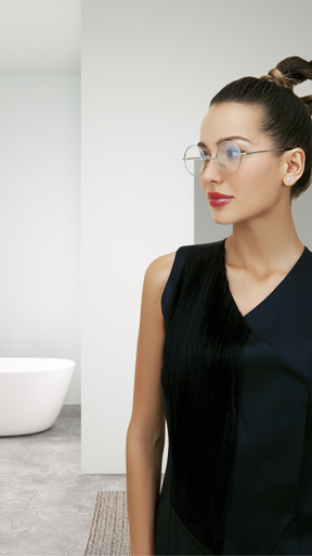 A woman wearing glasses standing in a bathroom