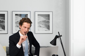 A man in a suit sitting at a desk with a laptop