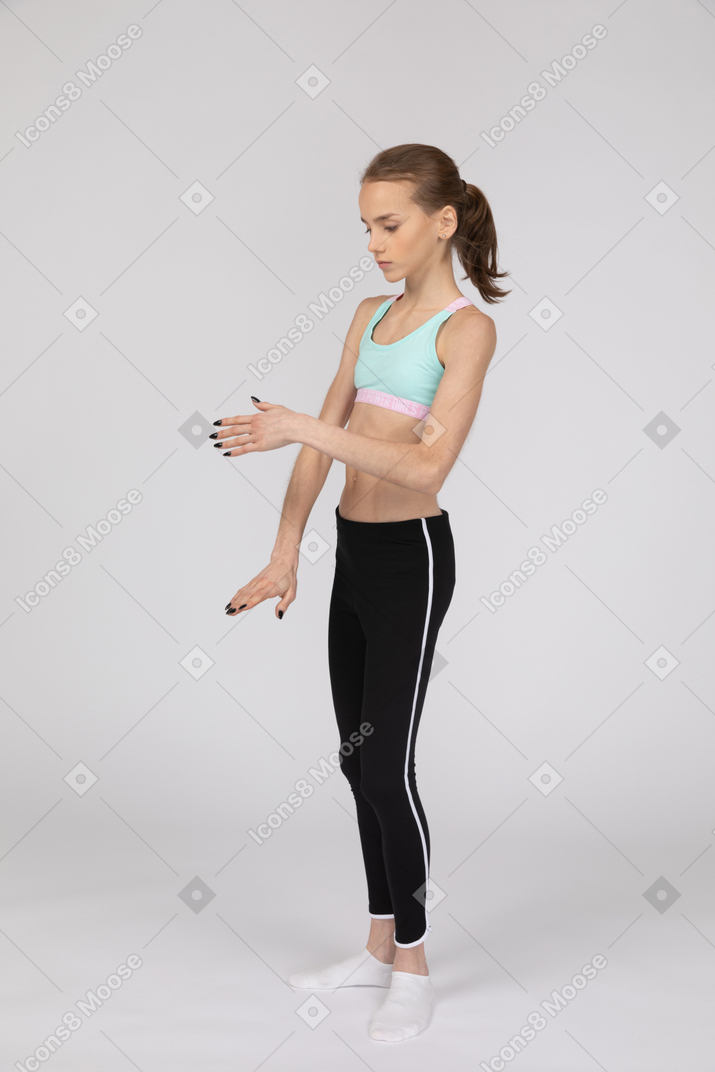 Side view of a teen girl in sportswear outstretching hand and touching arm