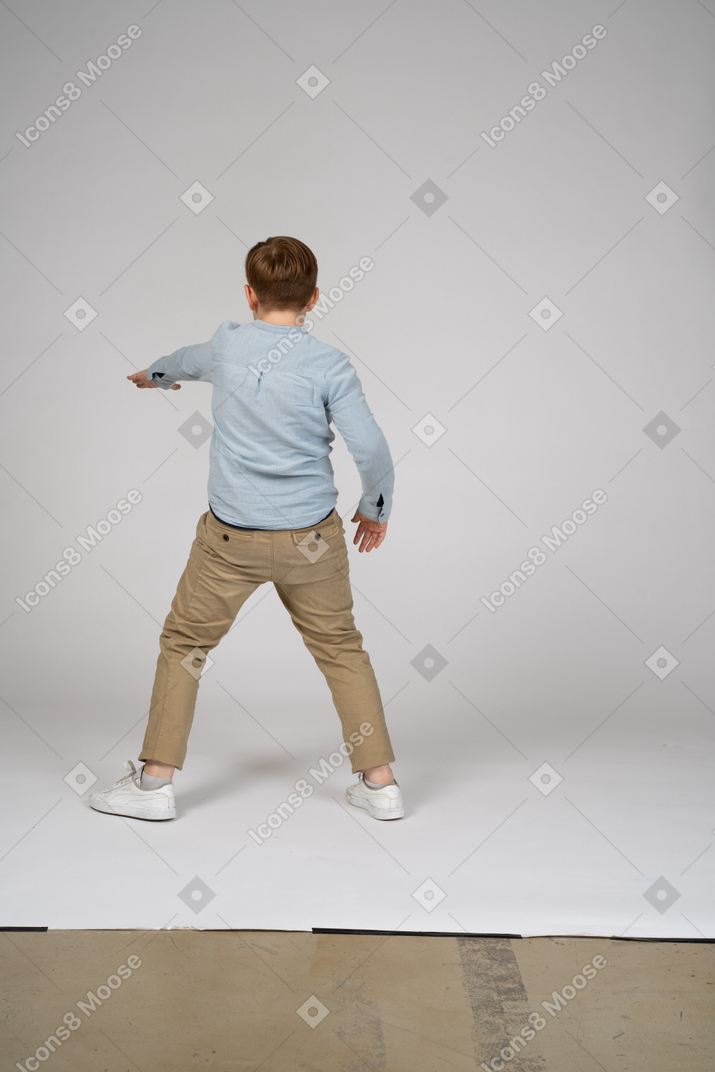 Homme debout devant un mur avec ses jambes croisées