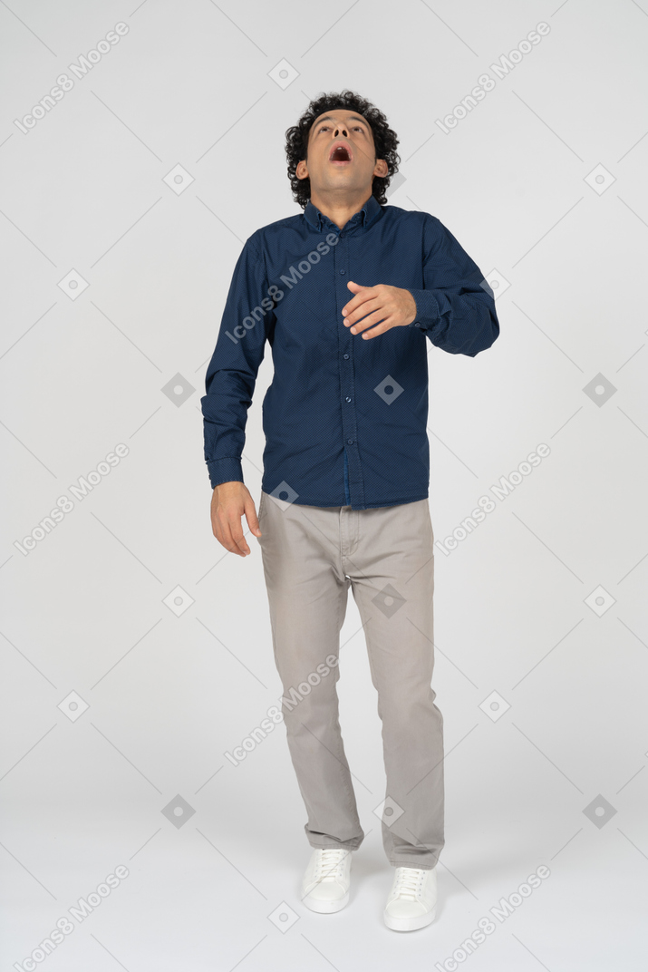 Front view of a man in casual clothes sneezing