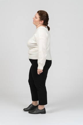 Plump woman in casual clothes standing in profile