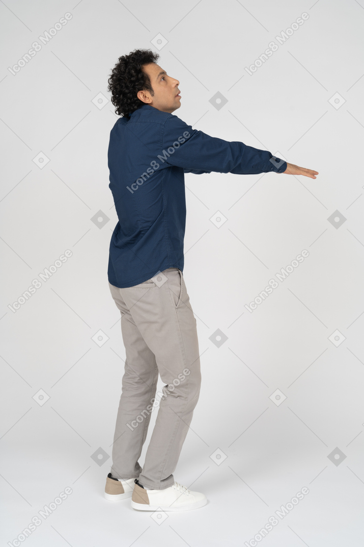 Vista laterale di un uomo in abiti casual in piedi con le braccia tese