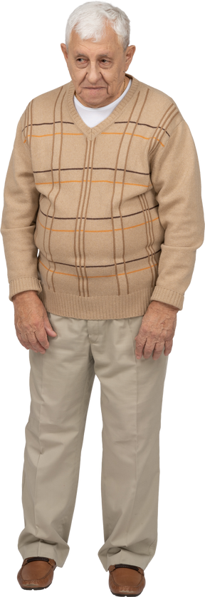 Vista frontal de un anciano con ropa informal mirando algo con interés