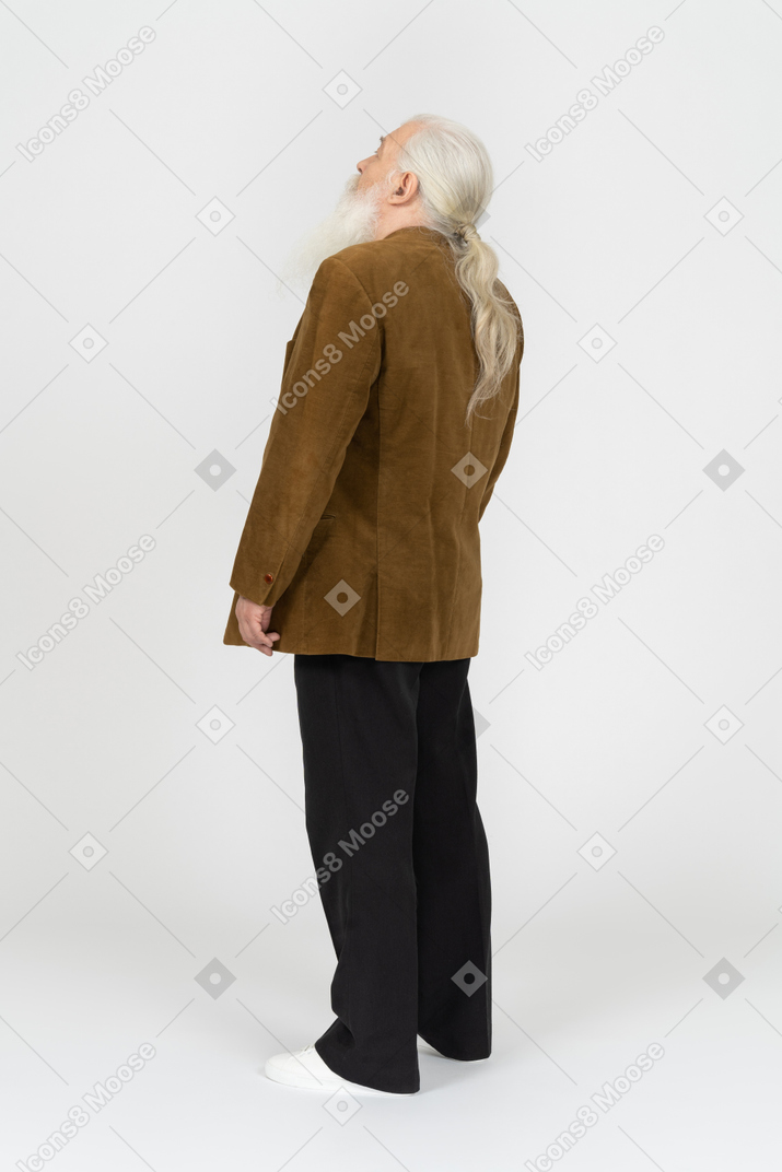 Old man standing with his back to camera and looking up