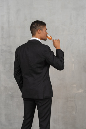 Back view of man drinking from a flute glass