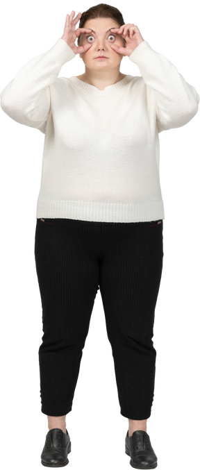 Mulher gorda com roupas casuais olhando através de um binóculo imaginário