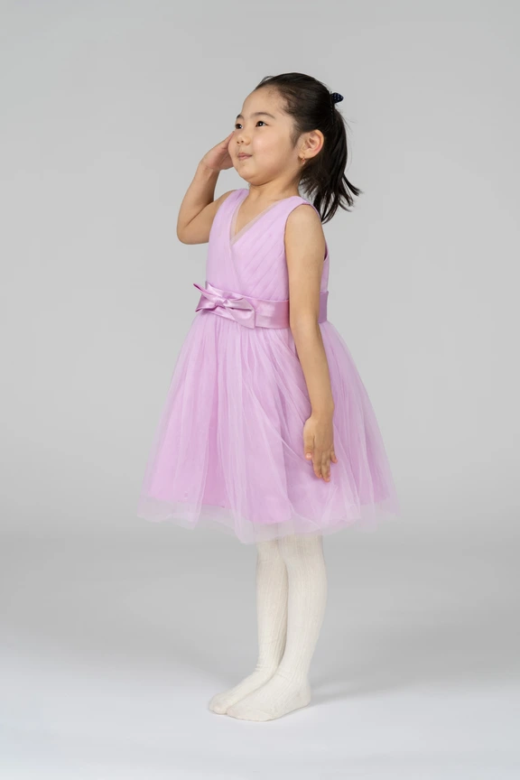 a little girl in a pink dress and white tights Stock Photo by Icons8