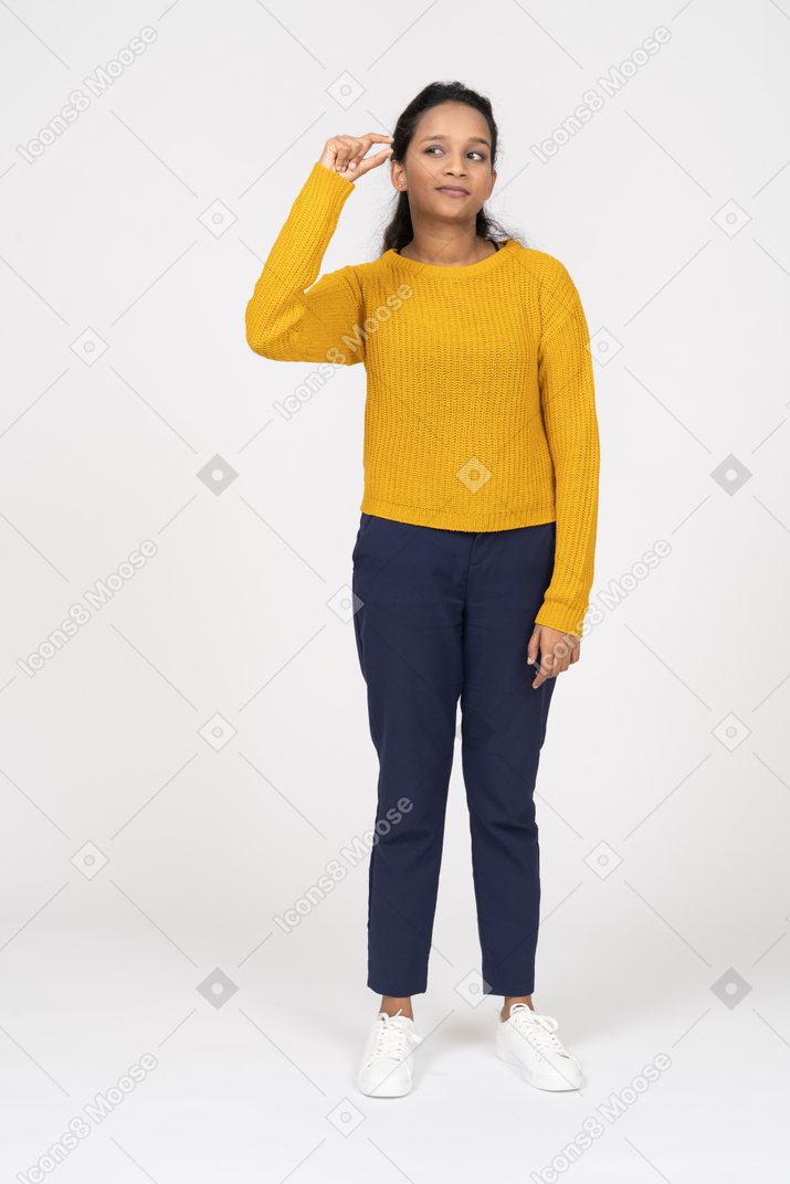 Vista frontal de una niña en ropa casual que muestra un tamaño pequeño de algo