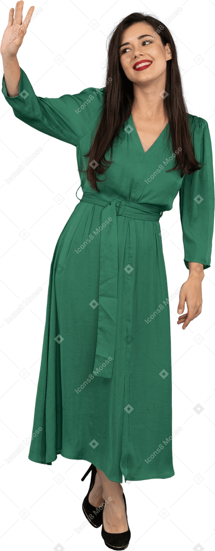 Vista frontal de uma saudação jovem de vestido verde