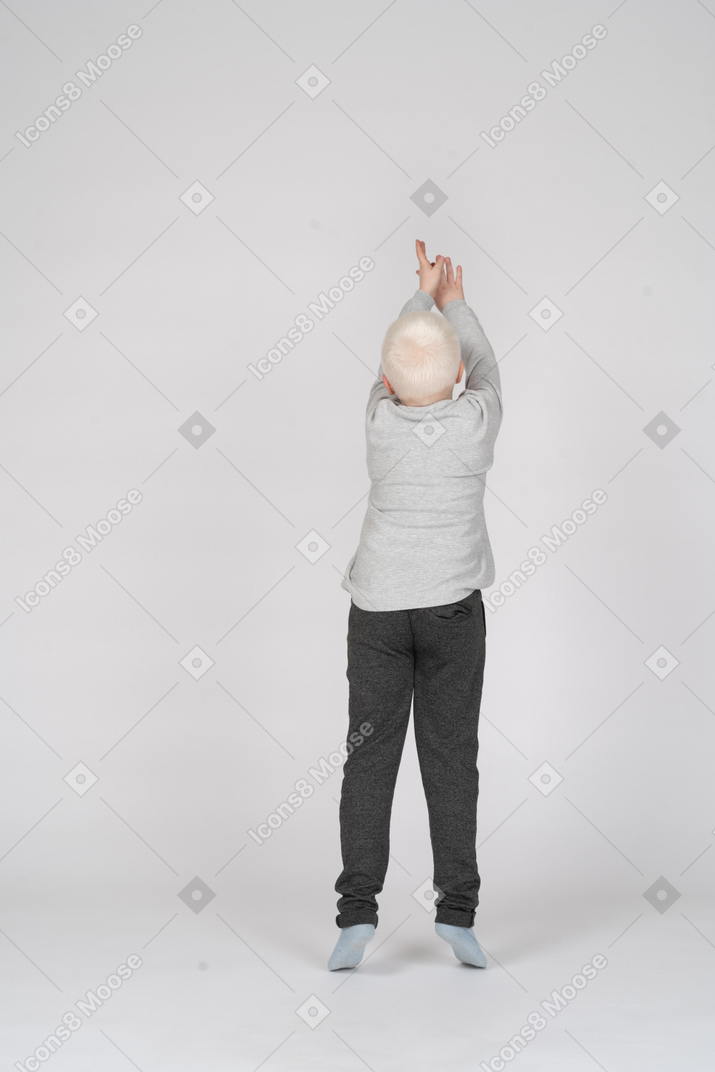 Vista posteriore di un ragazzo che si allunga con le mani