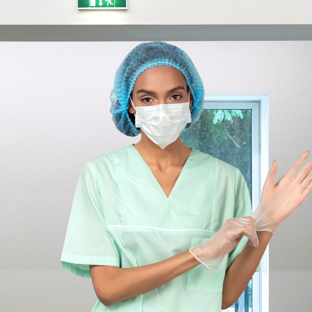 Nurse in face mask putting on gloves