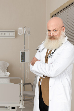 A man in a white lab coat standing in a hospital room