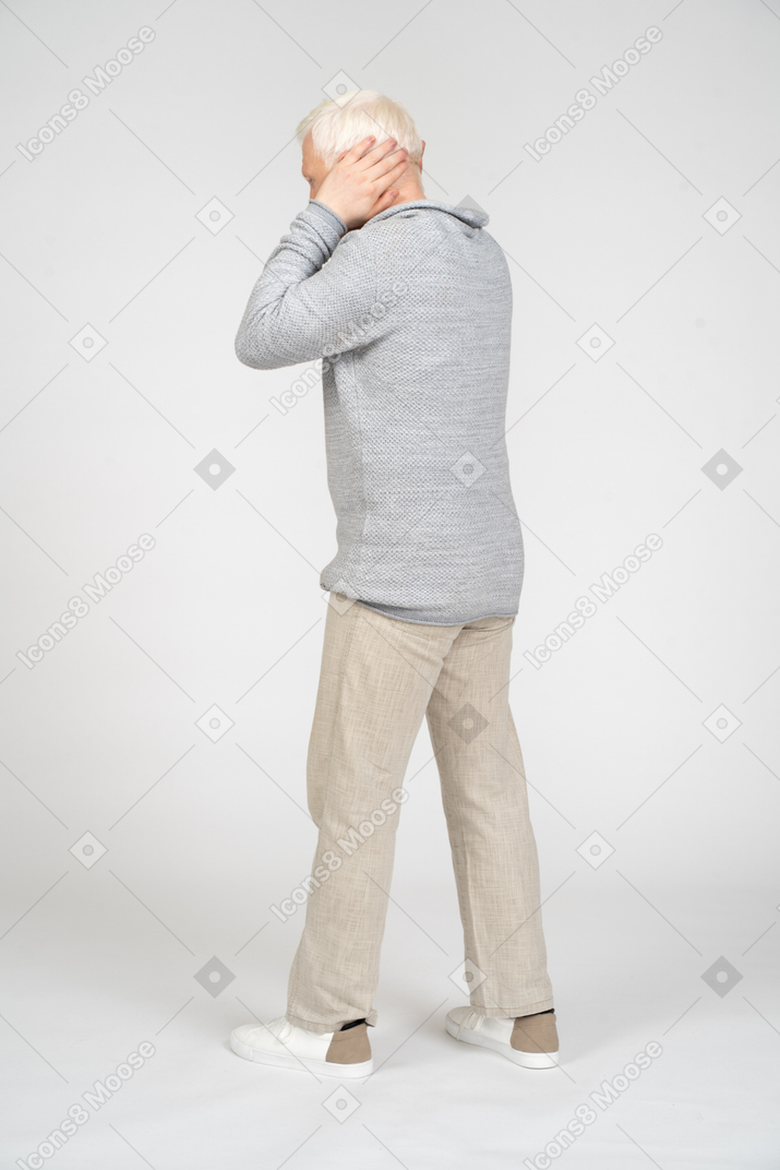 Man walking and covering his ears