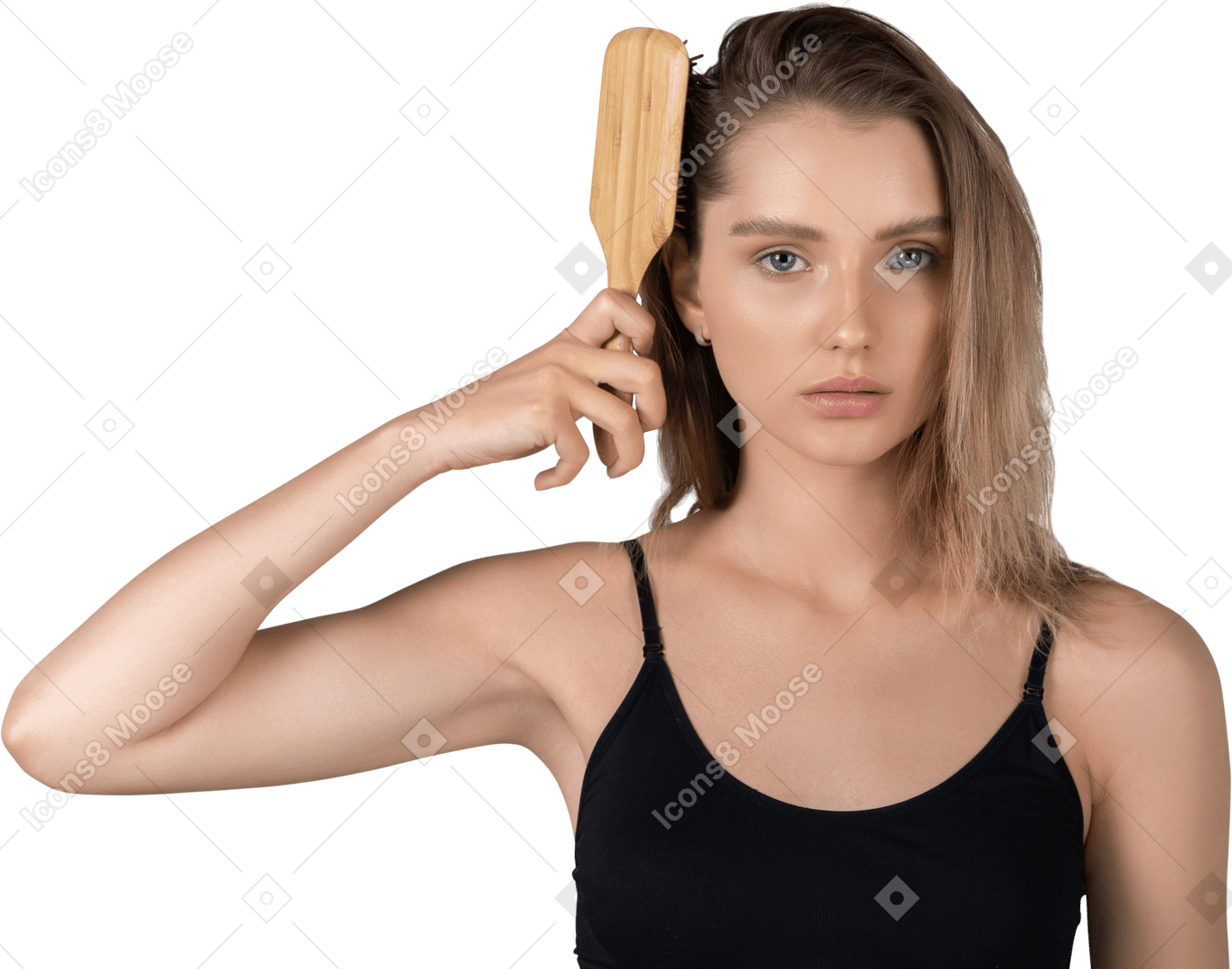 Front view of a young woman brushing her hairs