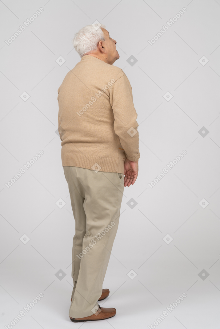 Vista trasera de un anciano con ropa informal mirando hacia arriba