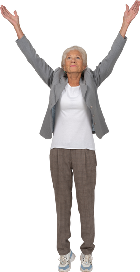 Vista frontal de uma senhora idosa de terno em pé com os braços erguidos