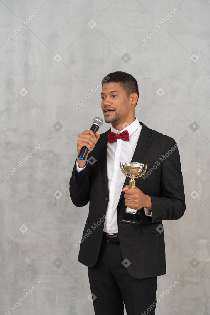 Man holding trophy and talking into mic