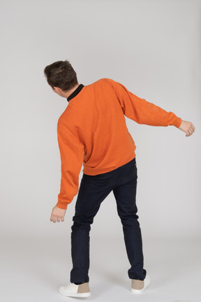 Junger mann im orange sweatshirt springen