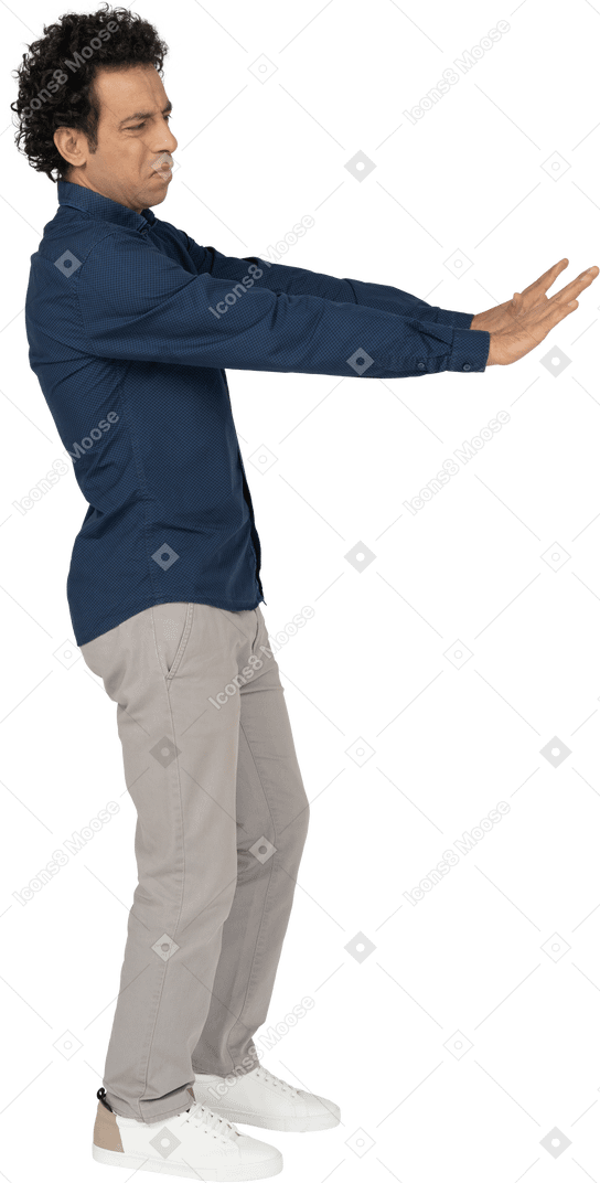 Side view of a man in casual clothes showing stop gesture