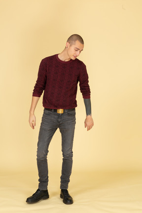 Front view of a young man in red pullover looking down