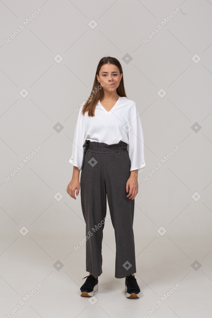 Front view of a smirking young lady in office clothing looking