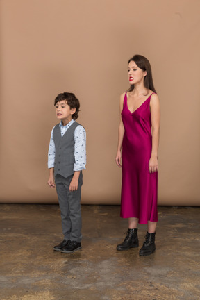 Side view of a young woman in red dress and boy