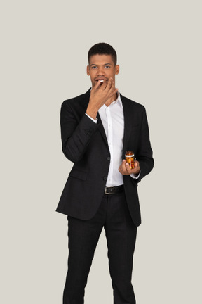 African american man in black suit taking pills