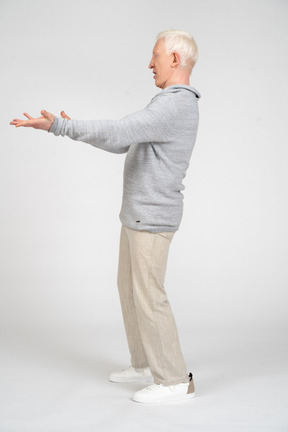 Side view of a man standing and reaching out his arms