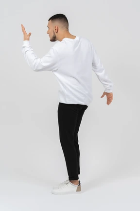 Back view of a man in casual clothes gesturing