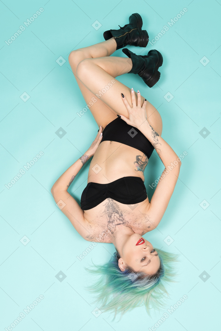 Sensual female in black lingerie lying on the floor