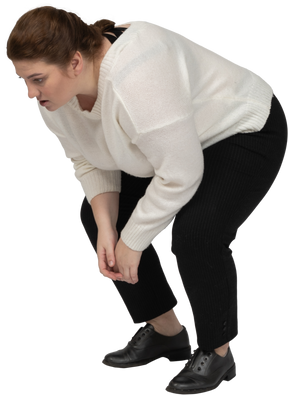 Side view of a plump woman in casual clothes bending down