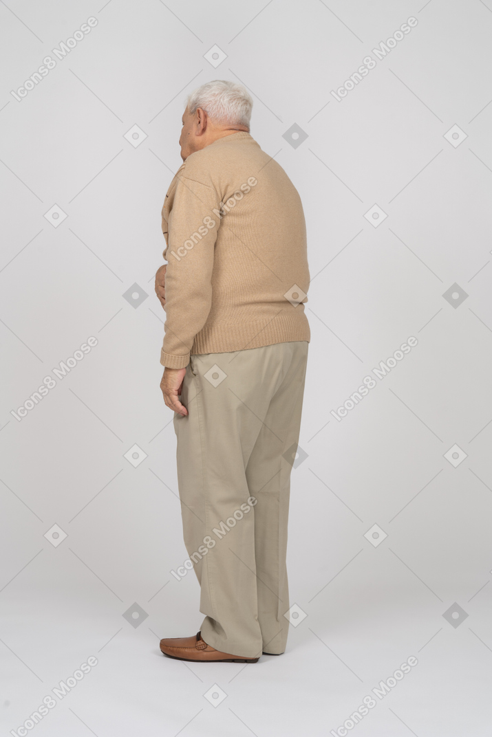 Vista lateral de um velho em roupas casuais, sofrendo de dor de estômago