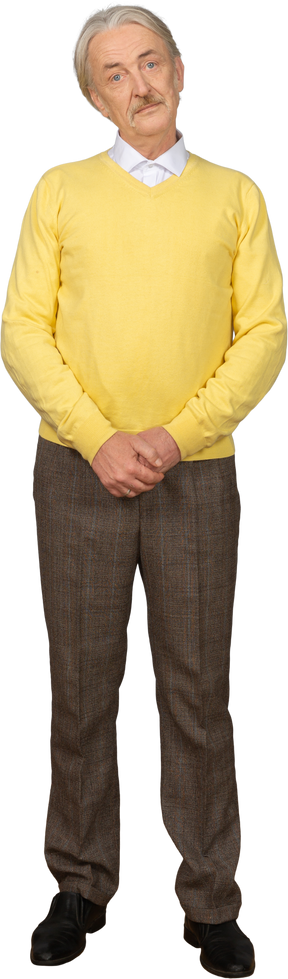 Vorderansicht eines verwirrten alten mannes, der hände zusammenhält und gelben pullover trägt