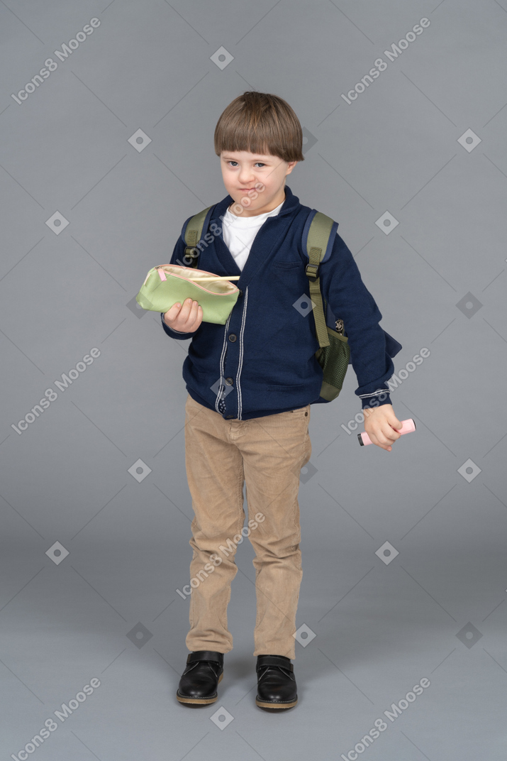 Schoolboy holding a pen and a pencil case