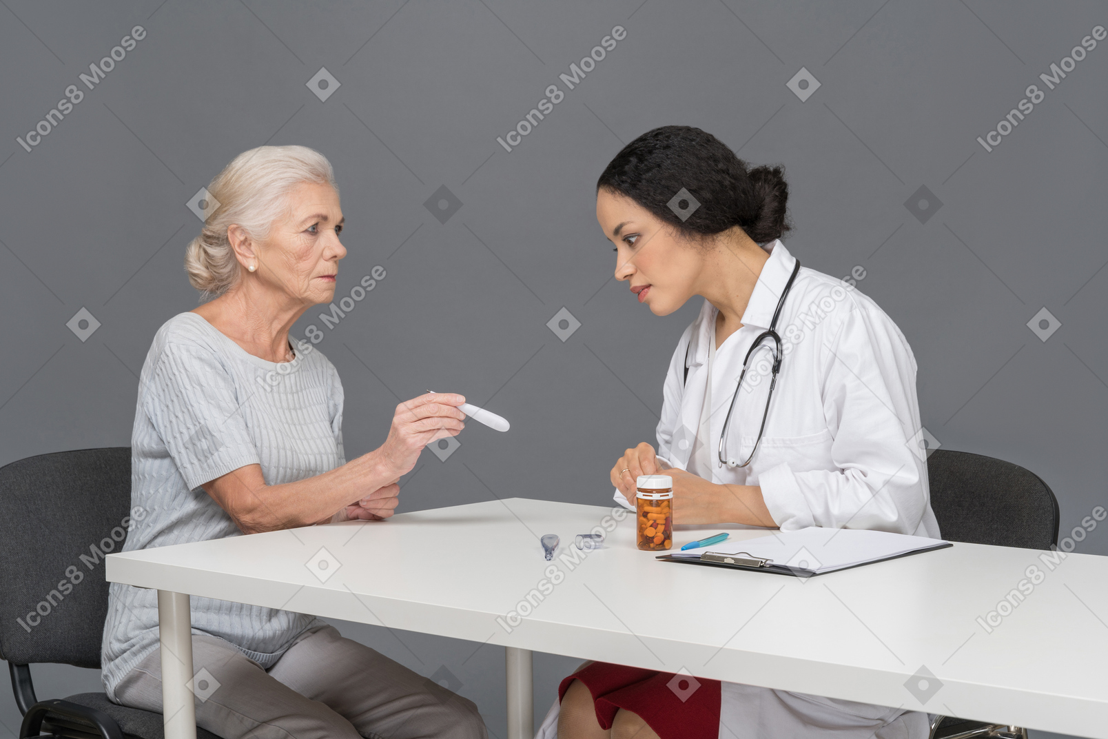 Пожилая женщина показывает термометр врачу