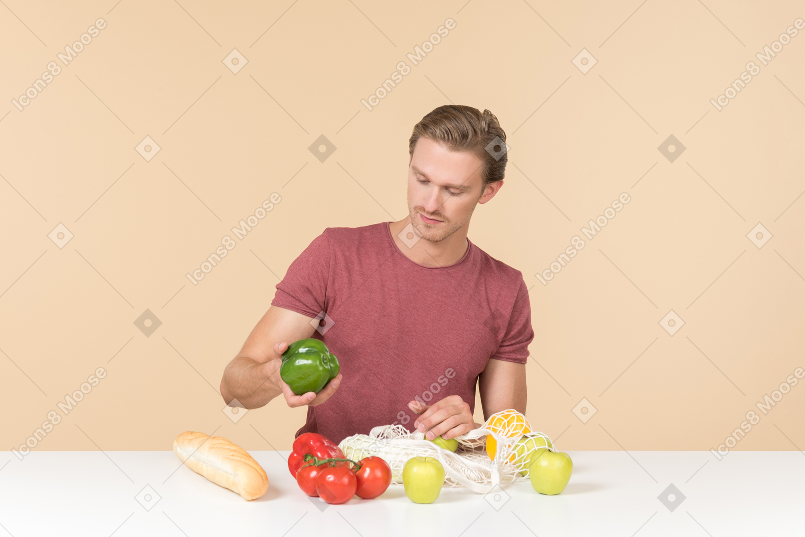 Young guy putting fruits and vegetables into a string bag