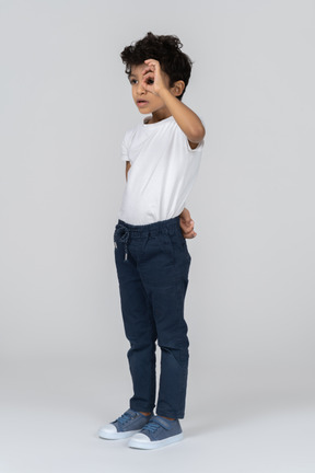 A boy looking through a finger ring