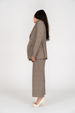 背を向ける茶色のビジネススーツの若い女性の側面図