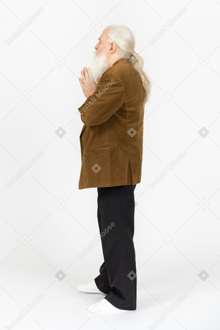Vista lateral de um homem idoso com as mãos postas