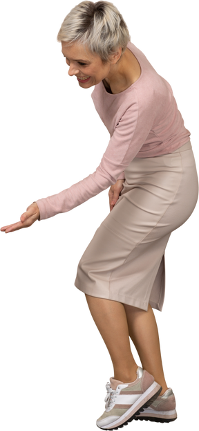 Side view of a happy woman in casual clothes showing a welcoming gesture