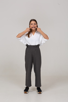 Vista frontal de uma jovem com uma careta em roupas de escritório