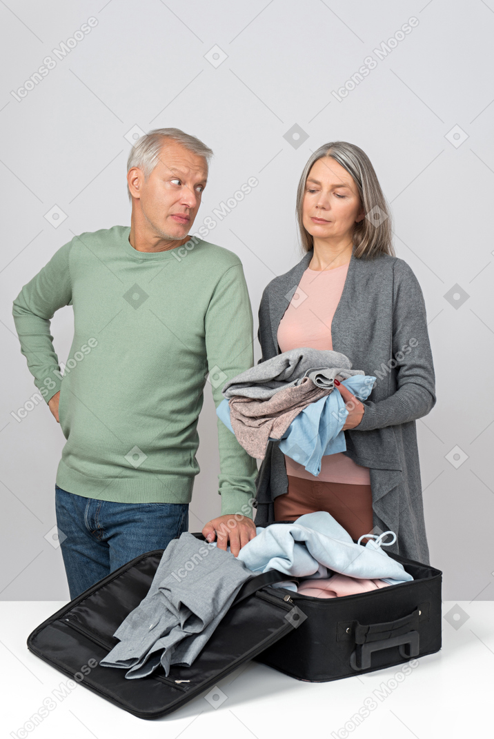 Middle aged couple packing a suitcase