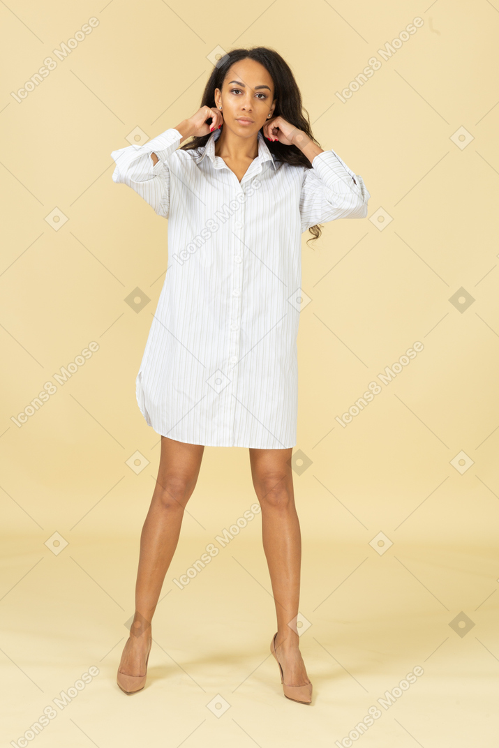 彼女の髪を固定している白いドレスを着た浅黒い肌の若い女性の正面図