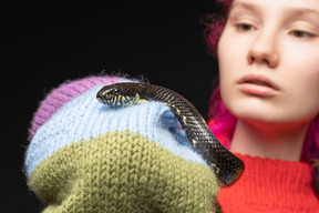 Jovem mulher segurando cobra listrada preta